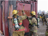 Firefighters using tools to open a container