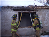 Firefighters tearing down window frame