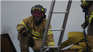 Firefighter crouched near ladder