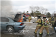 Firefighters putting out fire in car