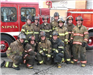 Firefighters posing in front of fire truck