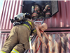 Firefighter removing mannequin from burning building