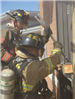 Firefighter opening window with halligan