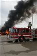 Firefighter on fire truck by fire
