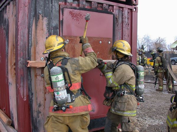 Firefighters using tools to open a container